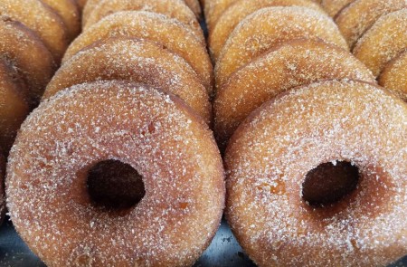 Delicious doughnuts powdered in sugar ordered in standing rows